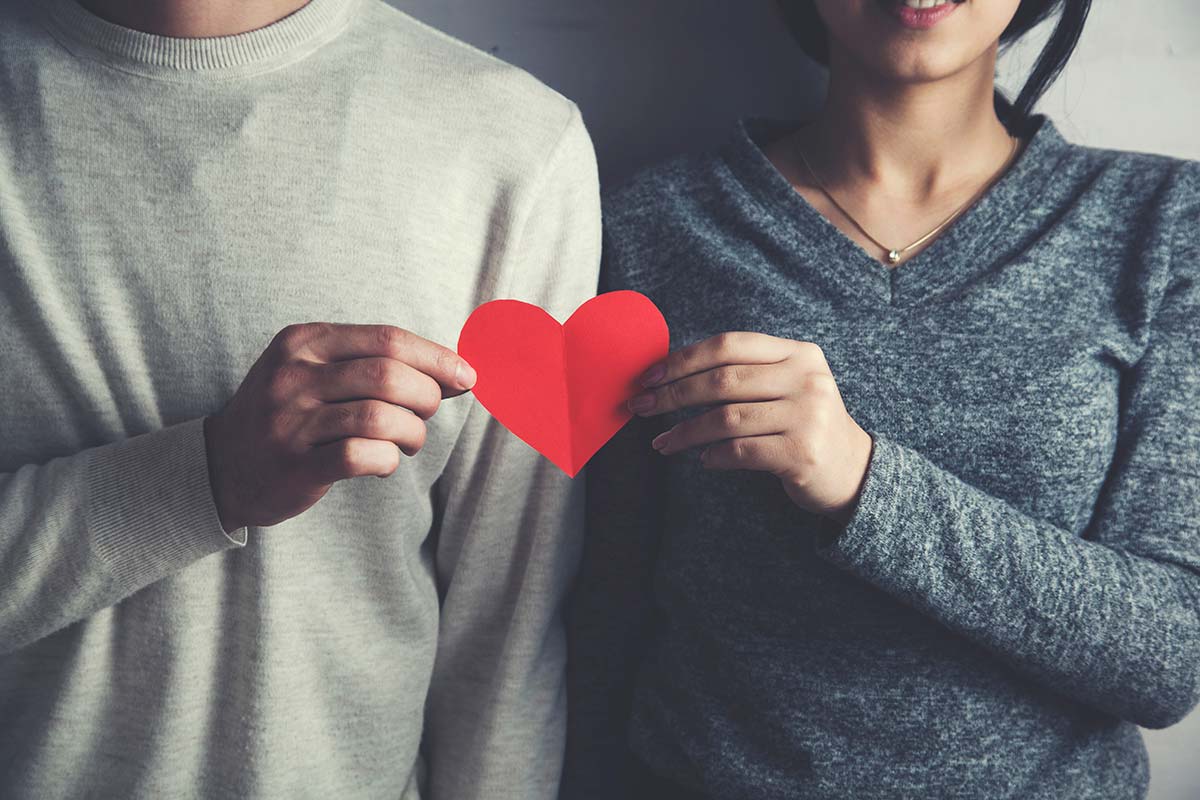 2 people holding a paper heart